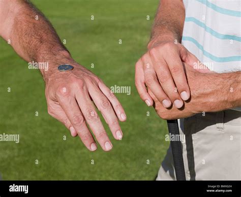 dos hombres maduros jugando al golf juntos tirando una moneda