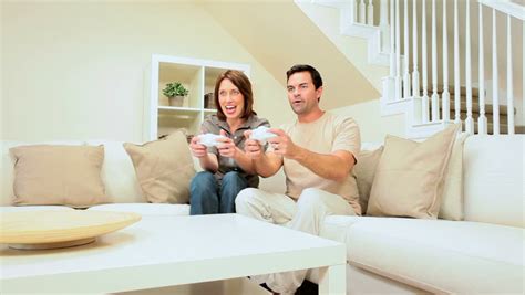 couple sitting on a sofa while watching a movie in their living room stock footage video 2390786