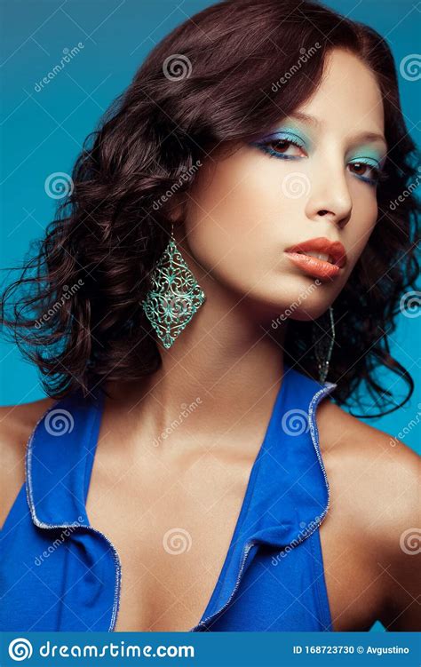 fashionable model with curly hair and arty make up posing