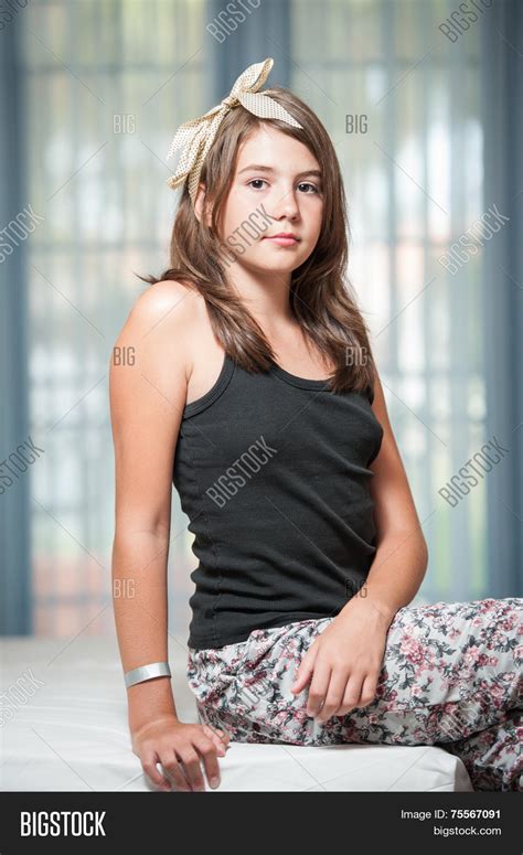 beautiful teen girl lying on bed and looking at camera