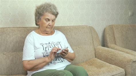 Old Granny Holding A Mobile Phone At Home By Vip Vn