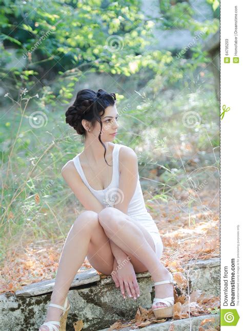 sexy slim lady wear tight short white dress sitting on
