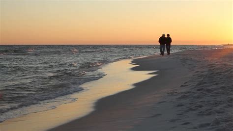 Mature Loving Couple Walk Toward The Camera On The Beach