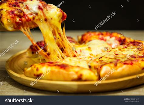 Hot Pizza Slice Dripping Mozzarella Cheese Foto Stock 1069471835