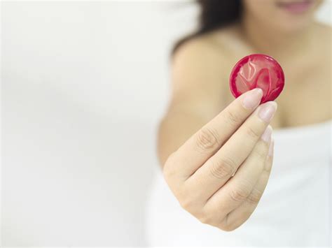 lady is giving red condom safe sex and contraception