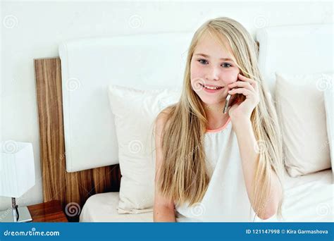 adolescente che si trova sul letto facendo uso di un telefono cellulare