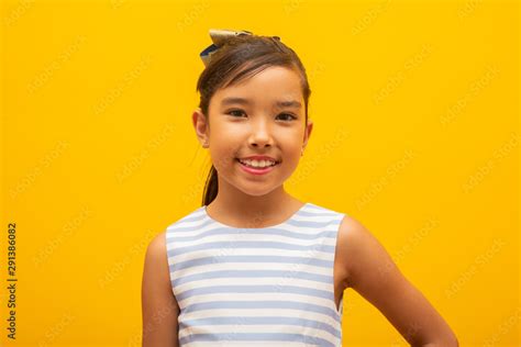 beautiful asian girl sitting on yellow background happy little asian