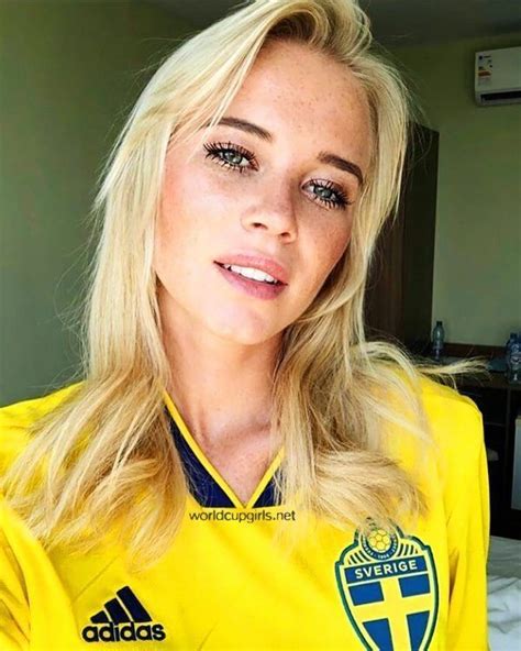 a woman with blonde hair wearing a yellow soccer jersey and looking at