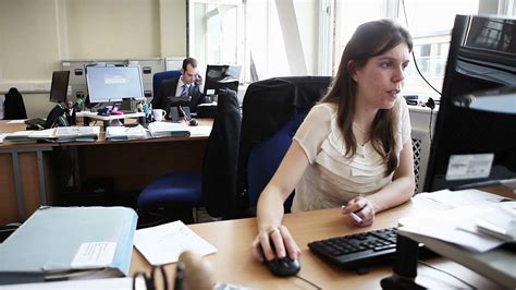 candid video footage   smartly dressed female office worker sitting   desk   real