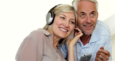 Cute Mature Couple Listening To Music Together At Home In