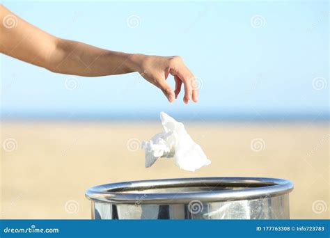woman hand throwing trash   bin   beach stock photo image  closeup collecting