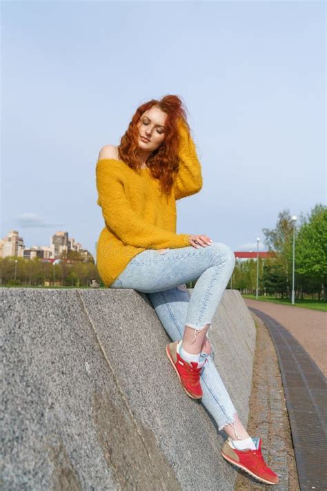 gorgeous happy redhead woman sitting on beaton and grass relaxing in