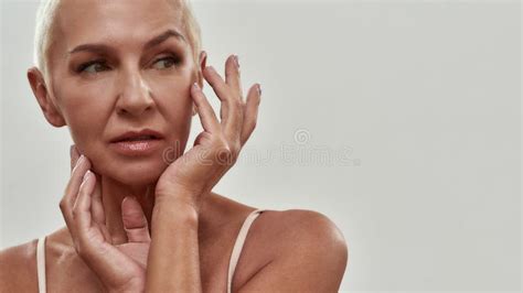 Happy Attractive Caucasian Mature Woman In Underwear Touching Her Face