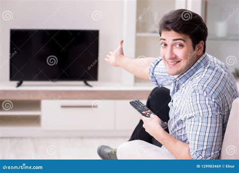 young man watching tv  home stock image image  film control