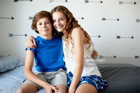 Brother And Sister In Their Bedroom Hugging And Looking At Camera High