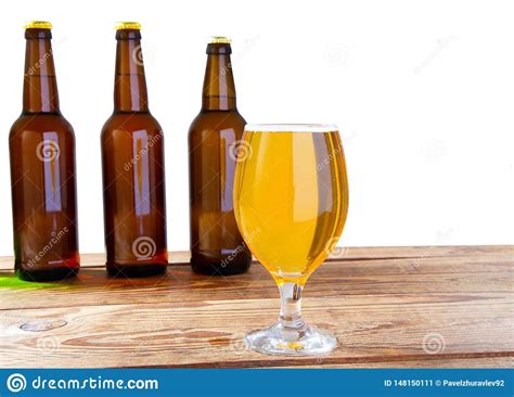 Glass Of Beer And Bottles With No Logo On Wooden Table