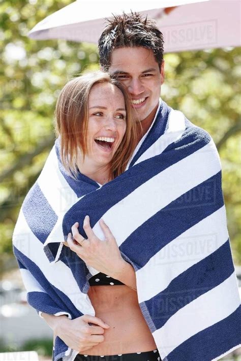 couple wrapped  striped towel enjoying sun stock photo dissolve