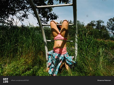 young girl hanging upside  exposing underwear  climbing frame