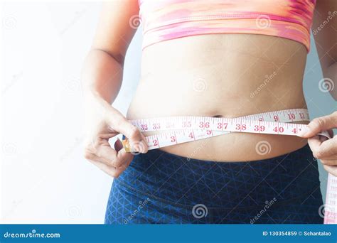 de sportieve vrouw die lichaam meten doet buikvet van de hand gezonde conce stock afbeelding