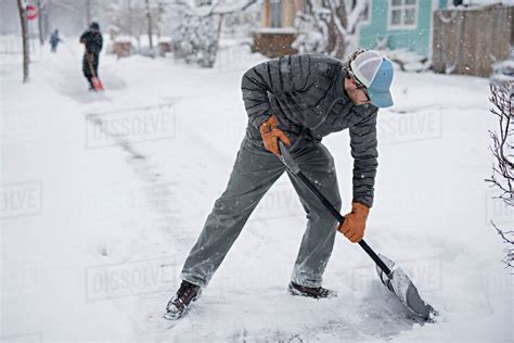 man shoveling snow  street stock photo dissolve