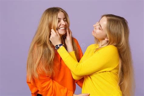 Two Cheerful Young Blonde Twins Sisters Girls In Vivid Colorful Clothes