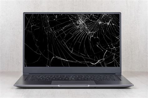 laptop   broken screen  cracks   gray background close  front view stock photo