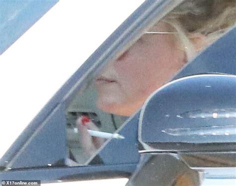 britney spears lights up a cigarette while taking her car out for a
