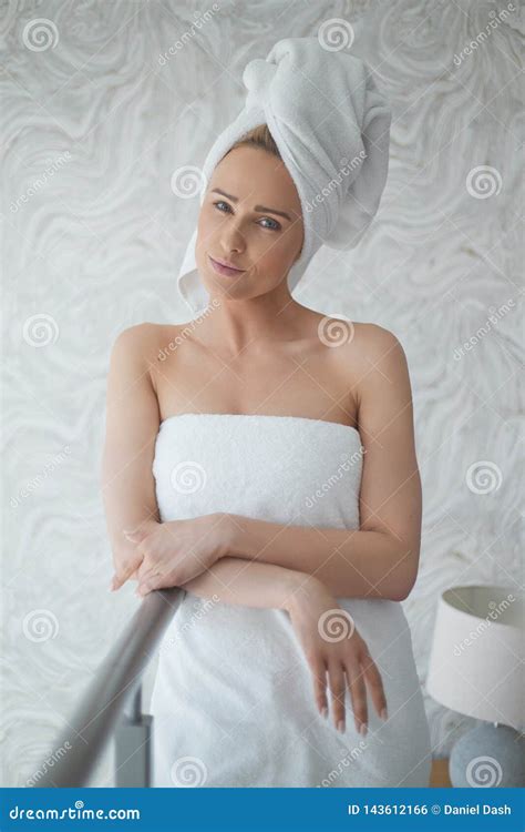 beautiful woman wrapped in a fresh white towel around her body and hair