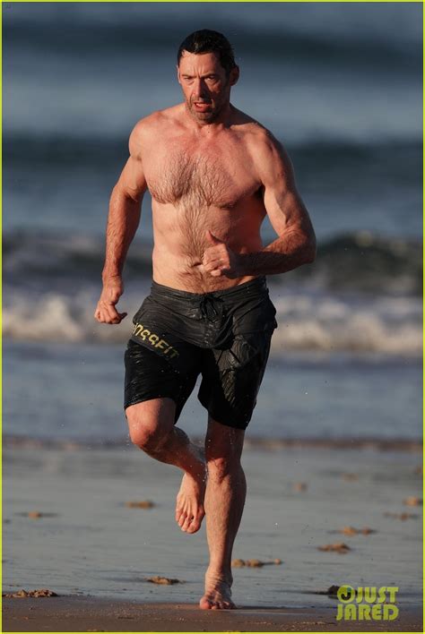 hugh jackman runs shirtless on the beach with his ripped muscles on