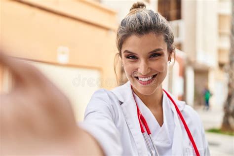 Young Blonde Woman Wearing Doctor Uniform Having Video Call At Street