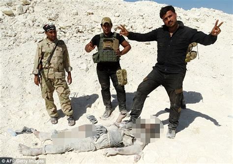 iraqi fighters pose next to the bodies of islamic state