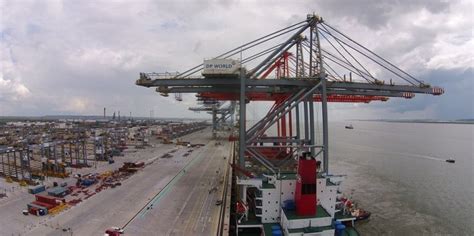 enormous quay cranes brought   river thames   berth  uks  logistics hub