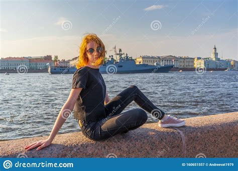 redhead teen tourist girl on neva river embankment posing