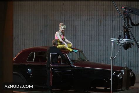 margot robbie sexy on top of a classic rolls royce during a reshoot for