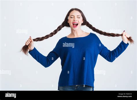 Amusing Pretty Young Woman With Closed Eyes Holding Her Two Long Braids