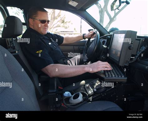 police officer checks  computer  patrol car stock photo royalty