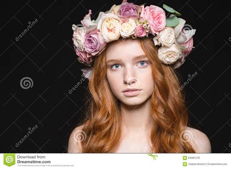 cute redhead woman with wreath from flowers on head stock