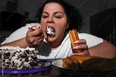 depressed overweight woman eating sweets in kitchen at night obrazy