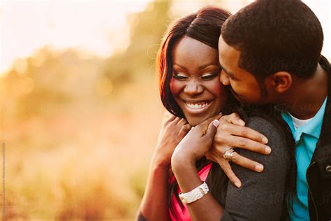 affectionate and happy black couple together outdoors by stocksy