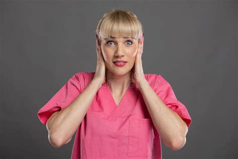 Portrait Of Young Attractive Female Nurse Covering Ears Stock Image