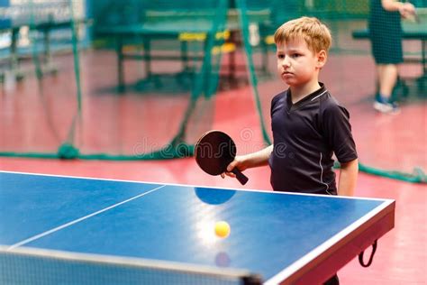 caucasian boy playing table tennis   blue table stock image