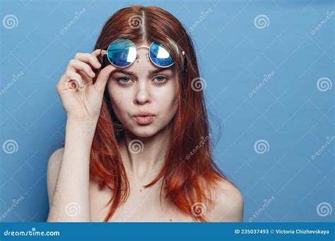 mujer pelirroja perky con lentes azules hombros desnudos posando imagen