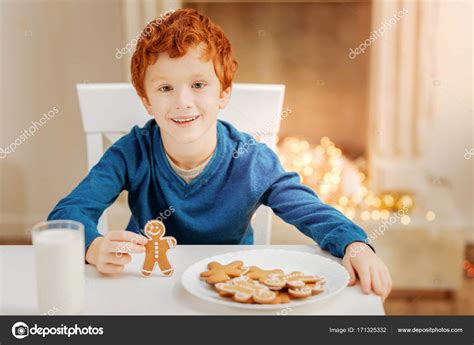 uśmiechający się rude dziecko jedzenie piernika na boże narodzenie rano — zdjęcie stockowe
