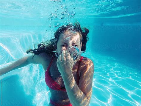 woman in bikini holding her breath underwater by jacob lund stocksy