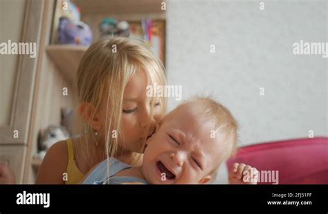 older sister soothing little crying brother stock video footage alamy