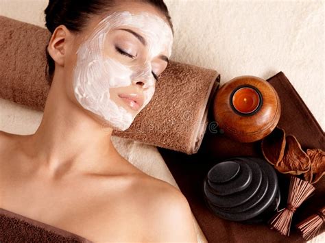 Woman Relaxing With Facial Mask On Face At Beauty Salon Stock Image