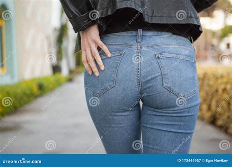 back or buttocks of a beautiful woman in jeans and leather jacket on