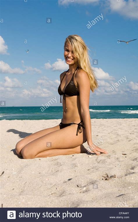 Female Very Long Blonde Hair Wearing Brown Bikini Kneeling