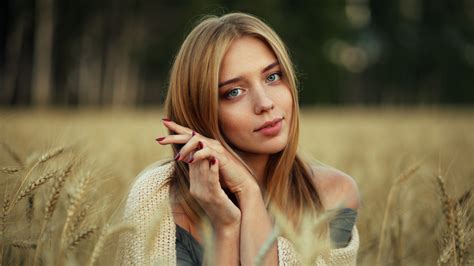 girl model  sitting  dry grass field  blur background posing   photo   hd