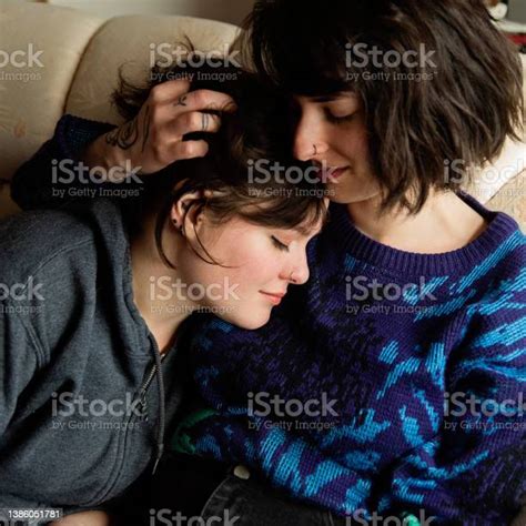 Lesbian Couple Enjoying Simple Pleasures At Home Cuddling On The Sofa